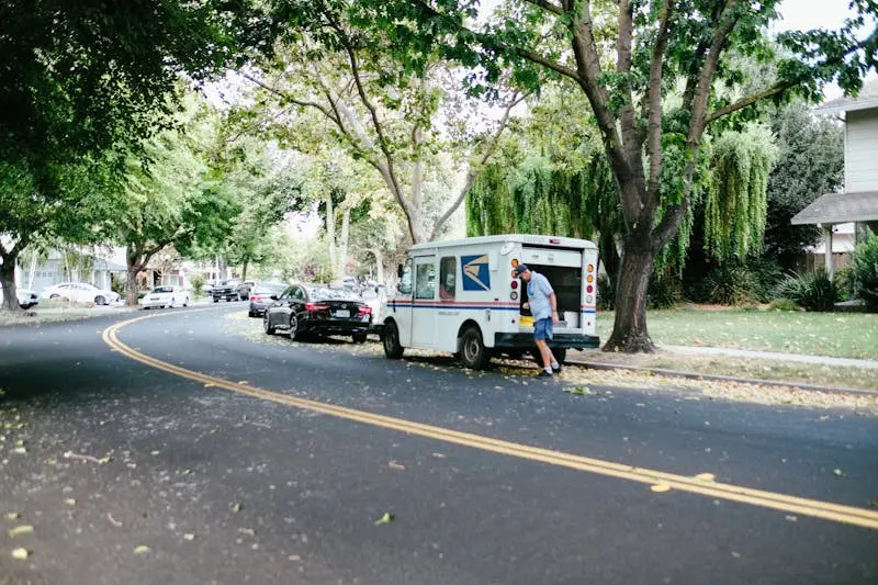 A Man Walking Beside USPS Mail Van More info Share